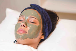 Mulher relaxando com máscara facial em spa.